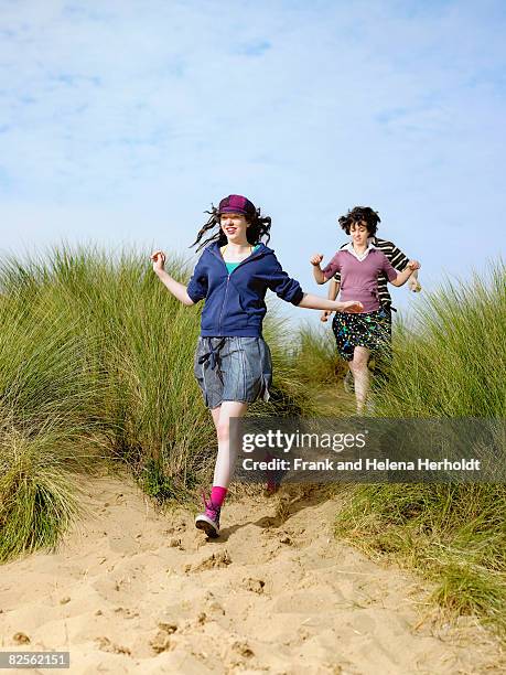 teenagers running downhill - croyde beach stock pictures, royalty-free photos & images