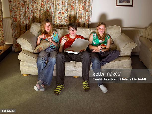 females and male on sofa, eating pizza - couch potato expressão em inglês - fotografias e filmes do acervo