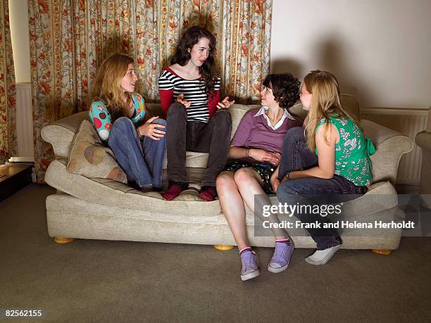 women, sitting on sofa, gossiping - croyde stock-fotos und bilder