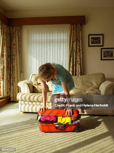 young female trying to close suitcase - feeling full stock pictures, royalty-free photos & images