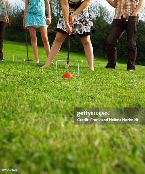 man and women playing croquet in garden - croyde stock-fotos und bilder