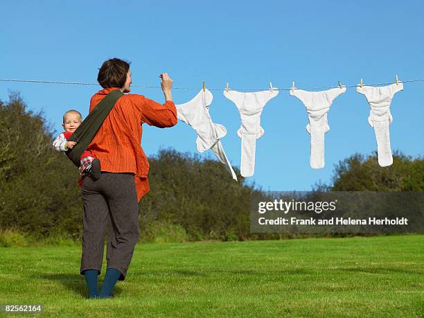 mother and baby hanging nappies outside - croyde stockfoto's en -beelden