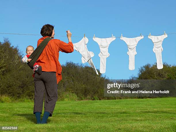 mother and baby hanging nappies outside - croyde stock pictures, royalty-free photos & images
