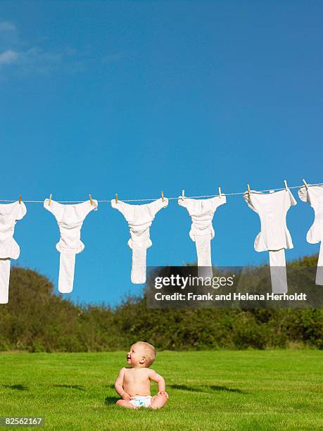 baby sitting on grass, looking up. - croyde stock pictures, royalty-free photos & images