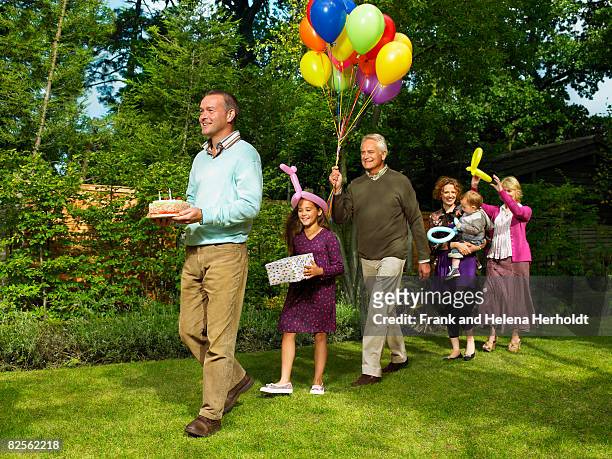 family arriving with birthday cake - kids party balloons stock-fotos und bilder