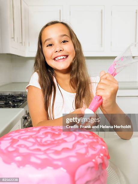 girl (8-10) icing cake - decorating a cake stock pictures, royalty-free photos & images