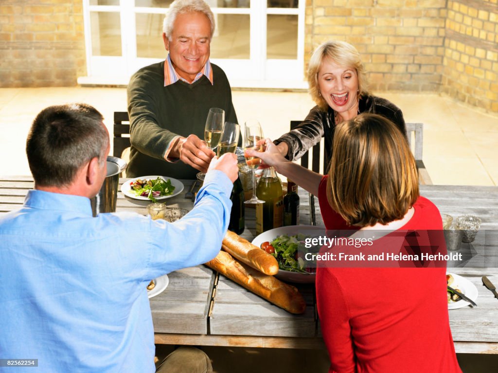 Two couples toasting with Champagne