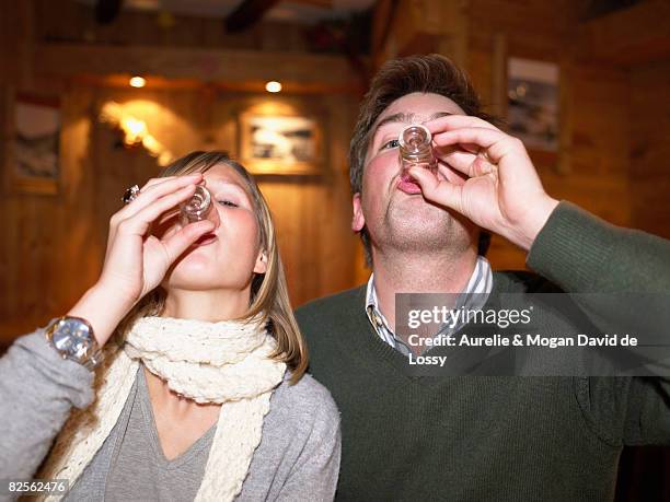 couple having shots in restaurant - meribel fotografías e imágenes de stock