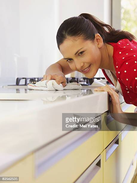 young woman cleaning kitchen surface - lappen stock-fotos und bilder