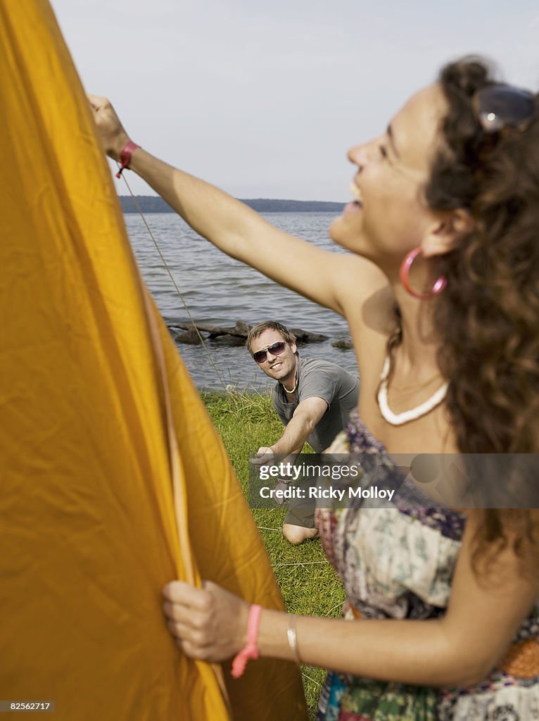 Man and woman putting up a tent