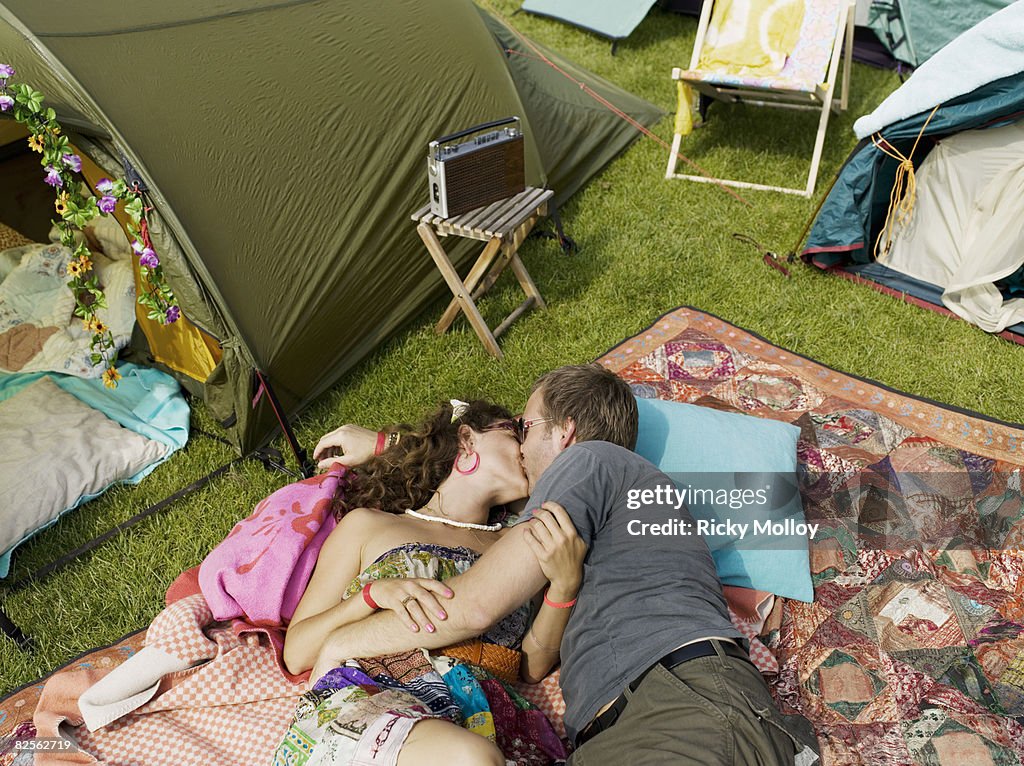 Woman and man laying kissing on blanket