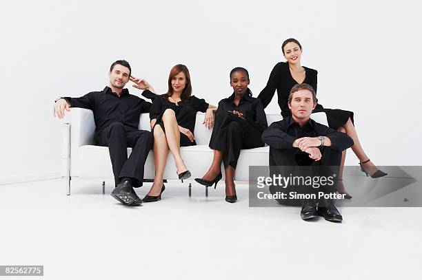 relaxed, seated business group - fond studio photo photos et images de collection