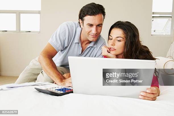 couple discussing bills on bed - budget reconciliation stock pictures, royalty-free photos & images