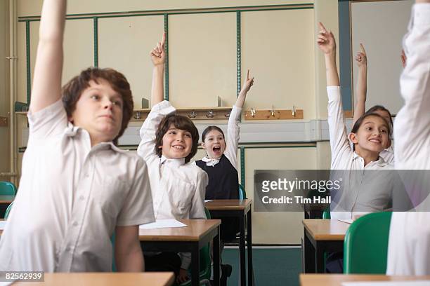 children raising hands in classroom - inside human mouth stock pictures, royalty-free photos & images