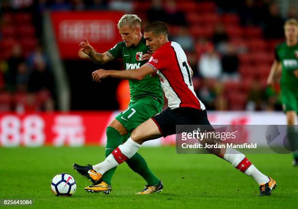 Oriol Romeu of Southampton tackles with Jonathan Schmid of FC Augsburg during the Pre-Season Friendly match between Southampton and FC Augsburg at St...