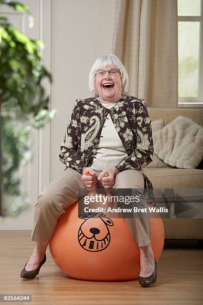 elderly woman bouncing on a space hopper - hoppity horse 個照片及圖片檔