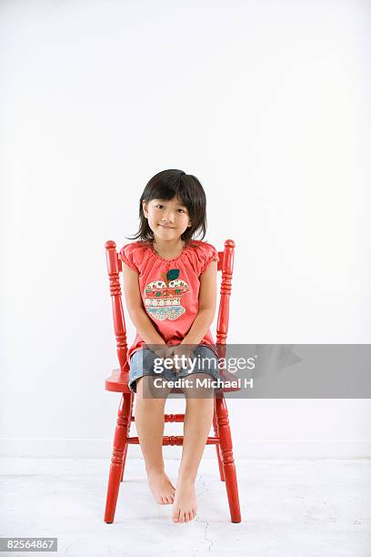 a girl is sitting on red chair - michael sit stock pictures, royalty-free photos & images