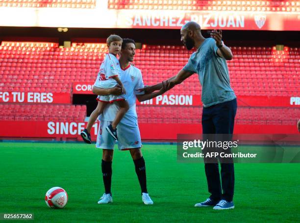 Sevilla's new footballer Jesus Navas poses with his son Jesus and former French footballer Frédéric Kanouté during his presentation at The Sanchez...