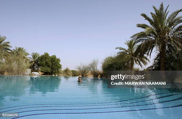 Foreigner enjoys the cool water in the middle of the desert at al-Maha resort and nature reserve, some 100 kms south of the Gulf emirate of Dubai, on...