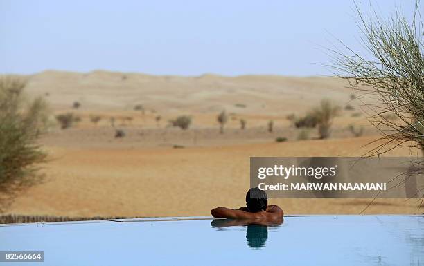 Foreigner enjoys the cool water in the middle of the desert at al-Maha resort and nature reserve, some 100 kms south of the Gulf emirate of Dubai, on...