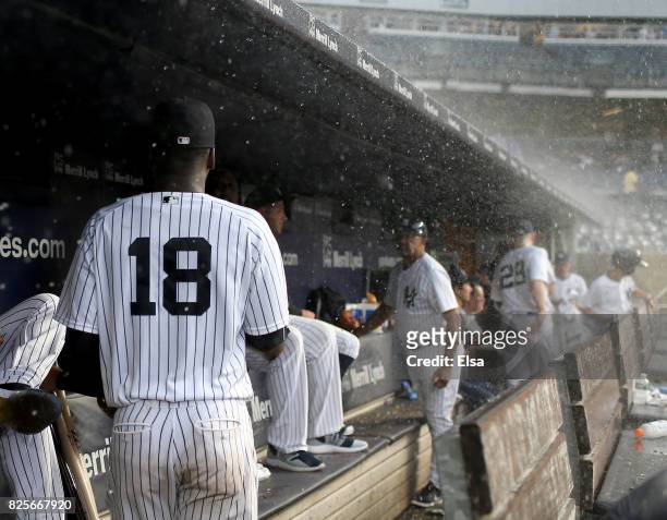 Didi Gregorius of the New York Yankees and the rest of his teammates head for the clubhouse as rain delays the game against the Detroit Tigers on...