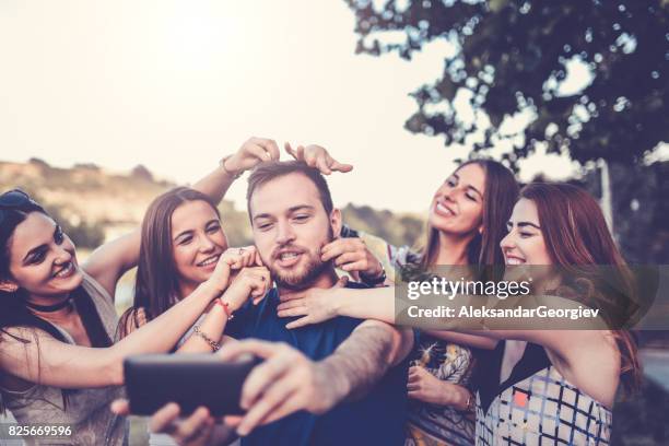 groep gekke vrienden selfie te nemen en het maken van gezichten buitenshuis - een pak voor de broek geven stockfoto's en -beelden