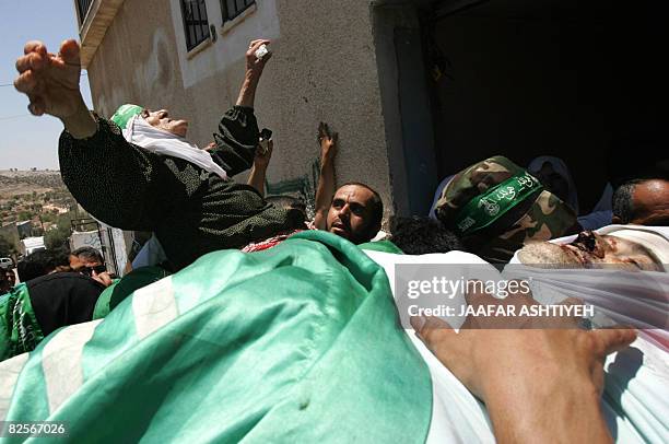 The mother of killed Palestinian Hamas member, Mahmud Assi, spreads her arms in mourning during Assi's funeral in the village of Karawa Bani Hasan...
