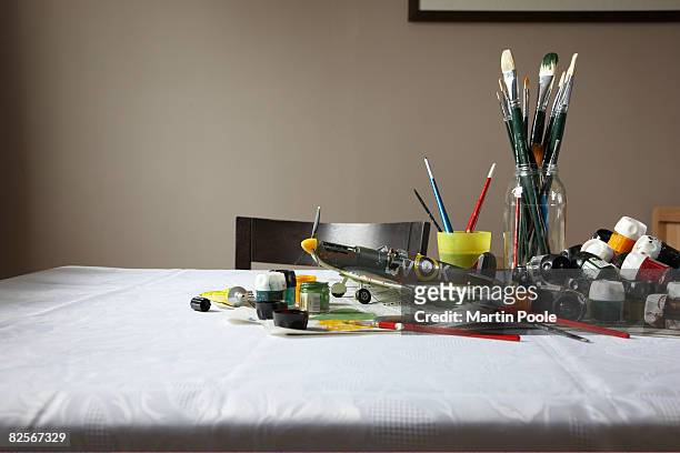 model plane on table with paint and brushes - model aeroplane stock pictures, royalty-free photos & images