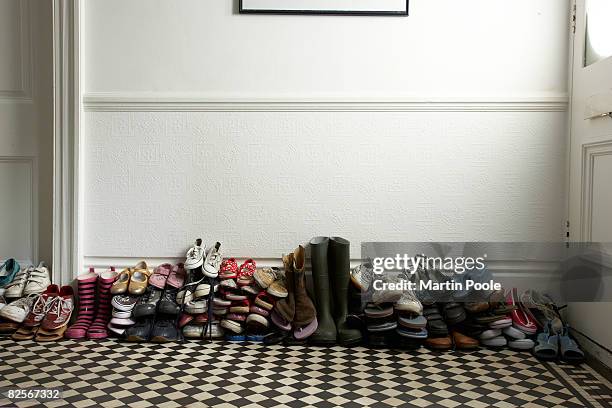 viele verschiedene schuhe liegen im flur - his shoes stock-fotos und bilder