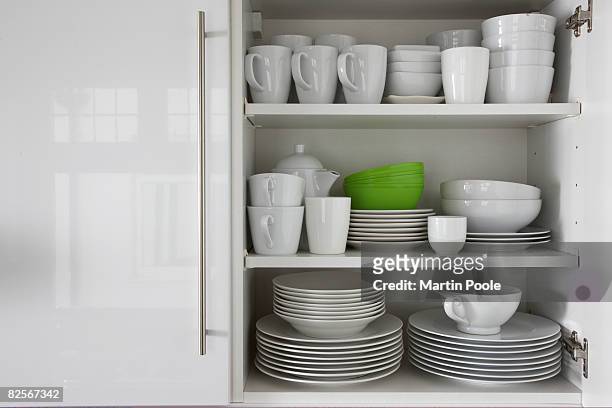 branco loiça empilhados no armário com verde bowl - dish imagens e fotografias de stock