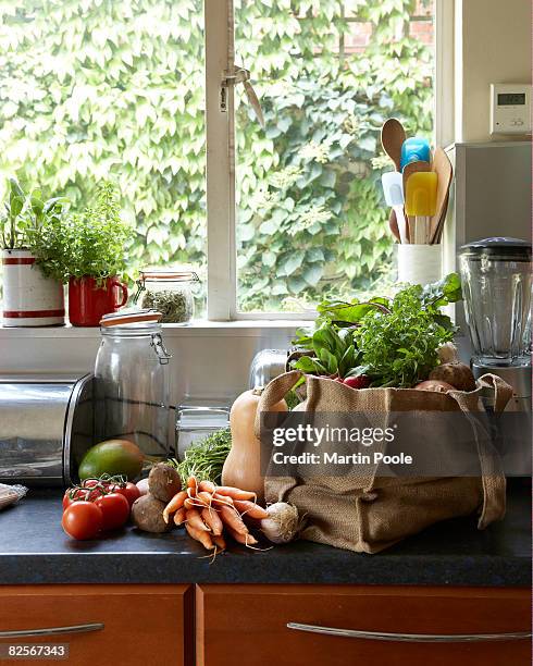 verduras frescas en bolsa de lona en mesa de preparación en la cocina - bolsa reutilizable fotografías e imágenes de stock