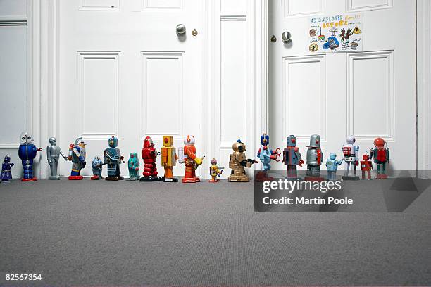 toy robots lined up outside childs bedroom - conformiteit stockfoto's en -beelden