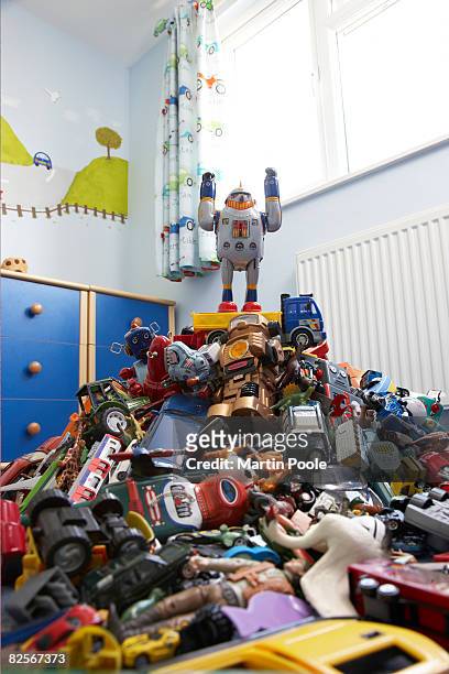a toy robot on top of pile of ro - child robot stock pictures, royalty-free photos & images