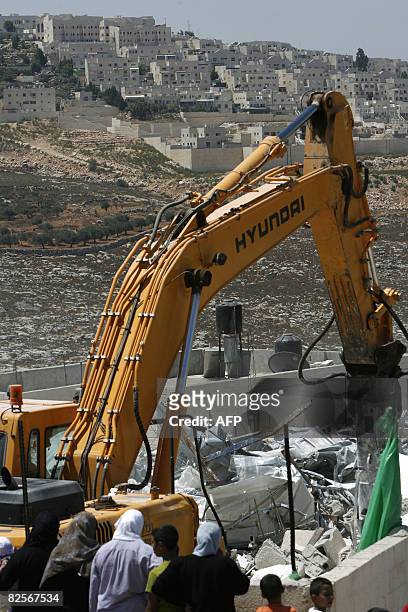 An Israeli army bulldozer demolishes a Palestinian house that was built without municipality permission in the Jerusalem Arab neighborhood of Beit...