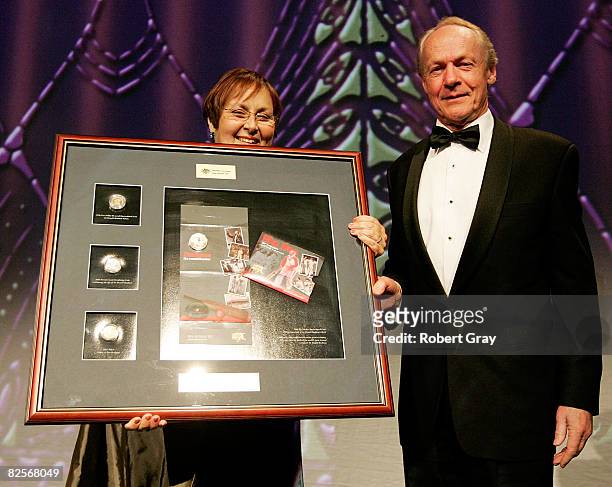 Janine Murphy of the Royal Australian Mint presents John Bradman with a Montage of a commemorative coin during the Sir Donald Bradman Centenary...