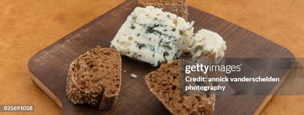 roquefort piece and cut baguette. - blue cheese crumble stock pictures, royalty-free photos & images