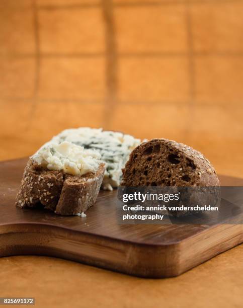 roquefort piece and cut baguette. - blue cheese crumble stock pictures, royalty-free photos & images
