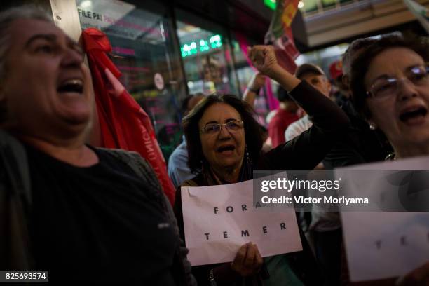 Protesters watch television on corruption trial against President Michel Temer in front of the Office of the Presidency of the Republic on August 2,...