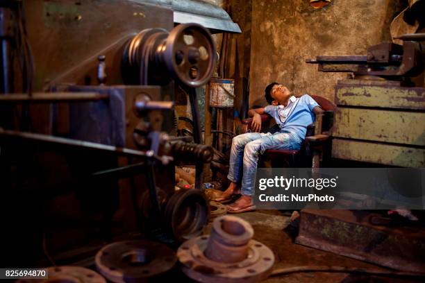 Child worker sleep in workshop in a dockyard in the side of Buriganga River at Dhaka August 2, 2017. The laborers work in the dockyard without proper...