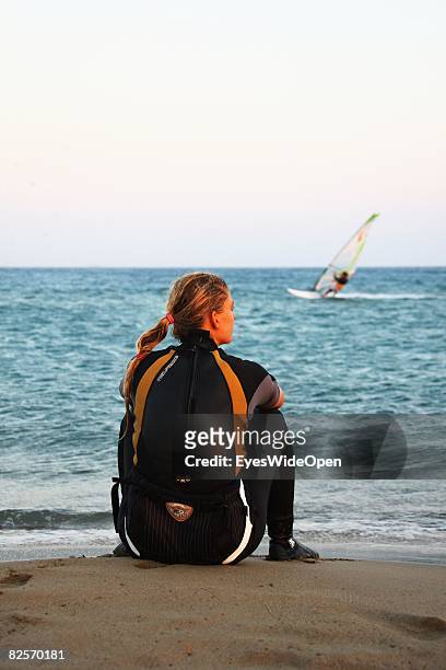 Woman in a wetsuit is watching the windsurfers in Prasonissi, on July 20, 2008 in Rhodes, Greece. Rhodes is the largest of the greek Dodecanes...