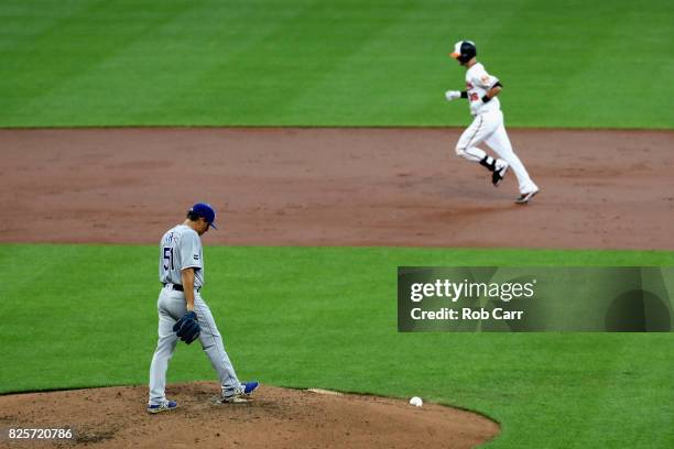 Starting pitcher Jason Vargas of the Kansas City Royals looks on as Caleb Joseph of the Baltimore Orioles rounds the bases after hitting a two RBI...