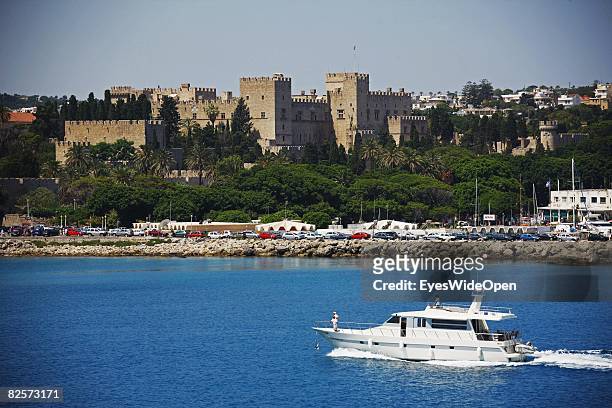 Yacht in the Mandraki Harbour is seen with the old town and the Palace of the Grand Masters on July 20, 2008 in Rhodes, Greece. Rhodes is the largest...