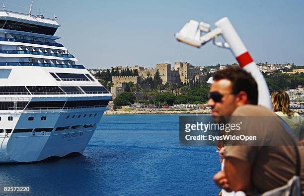 Cruise liner in Mandraki Harbour is seen with the old town and the Palace of the Grand Masters on July 20, 2008 in Rhodes, Greece. Rhodes is the...