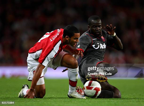 Theo Walcott of Arsenal gets tackled by Cheick Tiote of FC Twente during the UEFA Champions League third qualifying round, second leg match between...