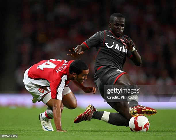 Theo Walcott of Arsenal gets tackled by Cheick Tiote of FC Twente during the UEFA Champions League third qualifying round, second leg match between...