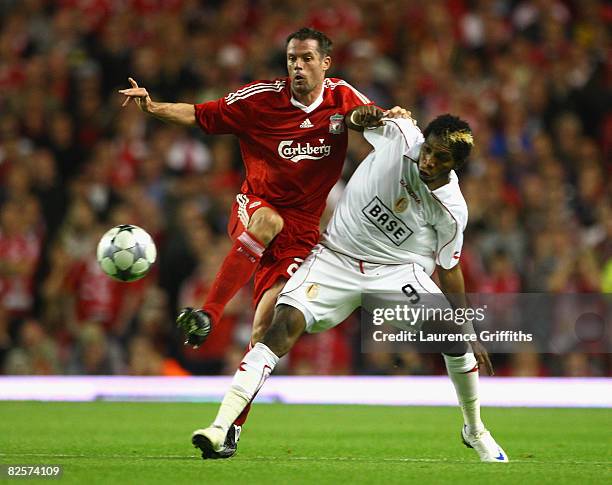 Jamie Carragher of Liverpool battles with Dieumerci Mbokani of Standard Liege during the UEFA Champions League Qualifier Third Round second Leg Match...