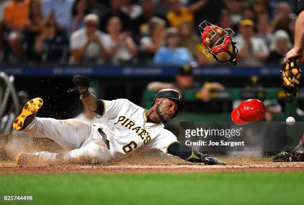 Starling Marte of the Pittsburgh Pirates slides into home plate during the sixth inning against the Cincinnati Reds at PNC Park on August 2, 2017 in...
