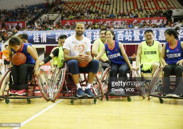 Player Tony Parker poses with disabled basketball players for photos at Guangxi Sports Center on August 2, 2017 in Guilin, Guangxi Zhuang Autonomous...