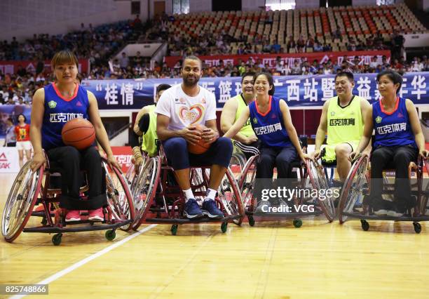 Player Tony Parker poses with disabled basketball players for photos at Guangxi Sports Center on August 2, 2017 in Guilin, Guangxi Zhuang Autonomous...