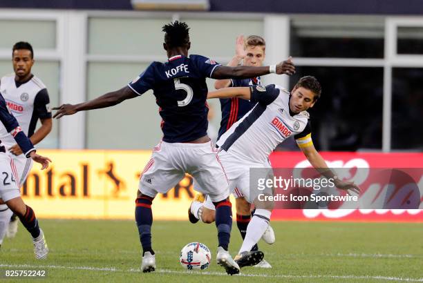 Philadelphia Union midfielder Alejandro Bedoya blocked by New England Revolution midfielder Gershon Koffie during an MLS match between the New...